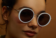 Charger l&#39;image dans la galerie, Lunettes de Soleil Femme Authentique GIGI BARCELONA modèle VENUS en Acétane et métal Doré brillant avec des cerceaux acétate en grus et des verrés dégradés en gris
